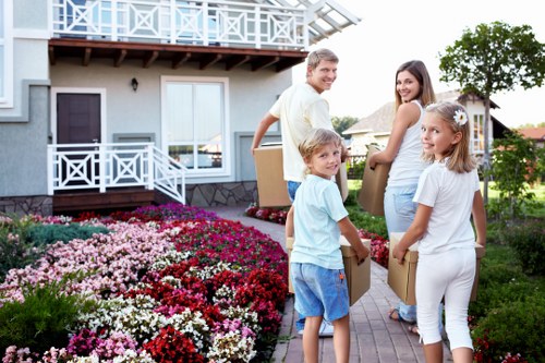 Driver assisting a customer with mobility needs next to a van in an urban neighbourhood